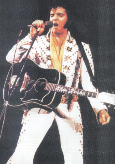 Elvis em concerto, com o escudo Kenpo na sua guitarra